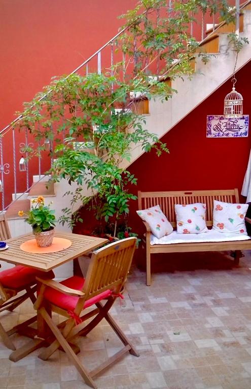 a patio with a table and chairs and a bench at S'Attobiu Guest Rooms in Teulada