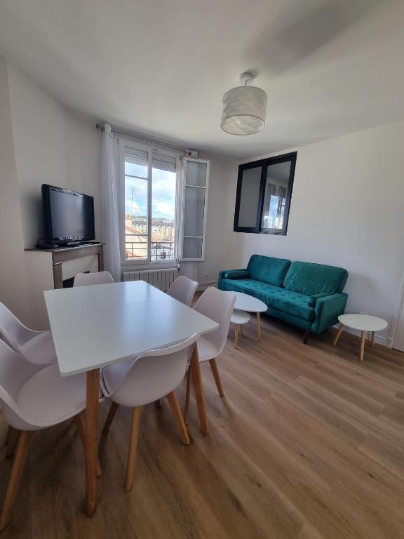 un salon avec un canapé, une table et des chaises dans l'établissement Appartement Cosy 3 chambres - Proche de Paris, à Arcueil