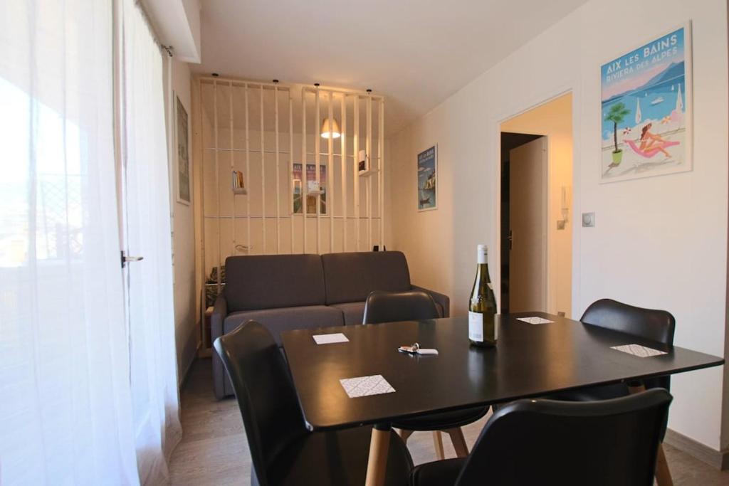 un salon avec une table et un canapé dans l'établissement Studio 25 m2 l'Aix'quise, hyper centre-ville, balcon, à Aix-les-Bains