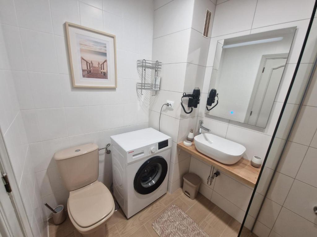 サンミゲル・デ・アボナにあるSunny Oasis Amarilla Golfの洗濯機と洗面台を備えたバスルーム