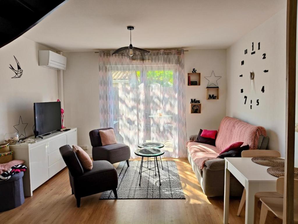 un salon avec un canapé, des chaises et une télévision dans l'établissement Le Cosy Dôme, à Cenon