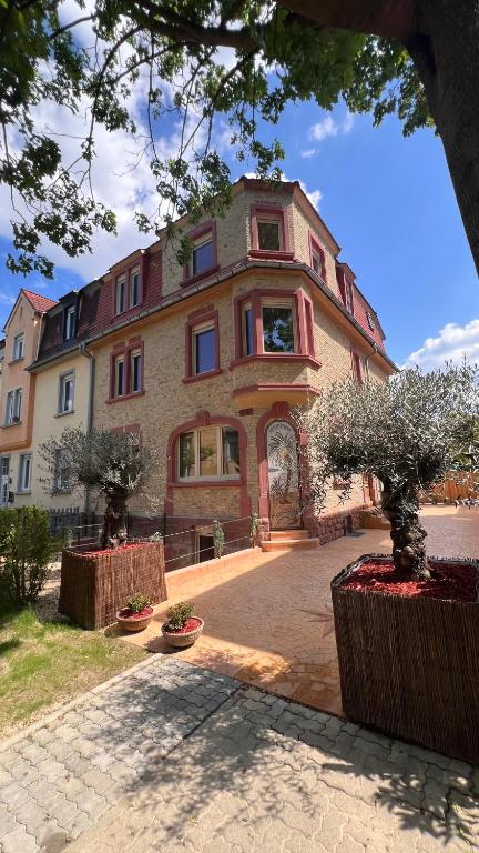 una grande casa con due alberi davanti di Villa Mediterrane - Apartment Milan a Frankenthal