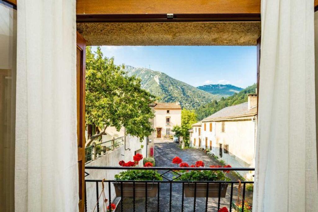 una vista da una finestra di una strada con fiori rossi di Gîte Le Boisset a Gincla