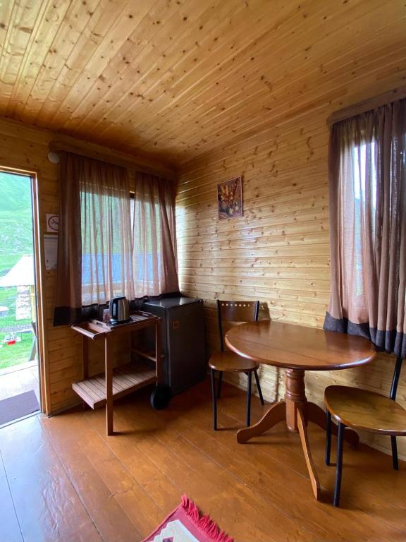 Habitación con mesa y escritorio en una cabaña en Ushguli Cabins, en Ushguli