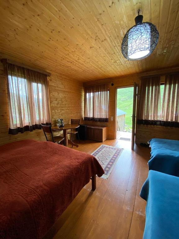 Un dormitorio con una cama y una mesa y sillas. en Ushguli Cabins, en Ushguli
