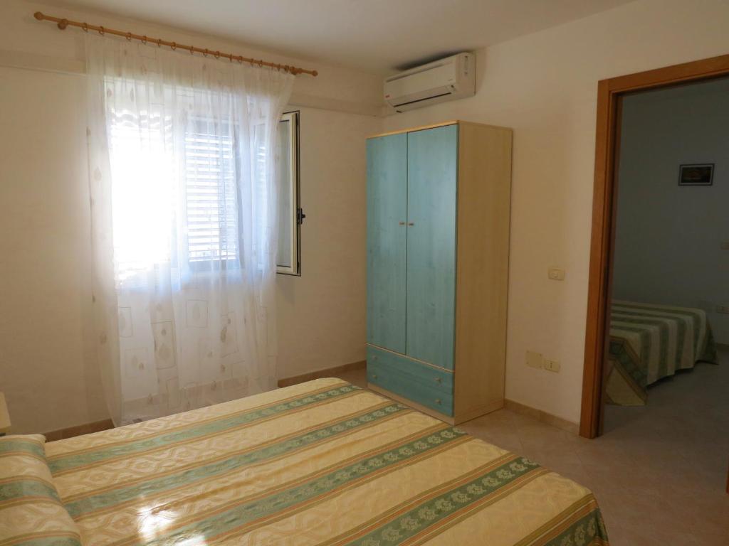 a bedroom with a blue cabinet and a window at Hotel Residence Villa Ascoli in Vieste