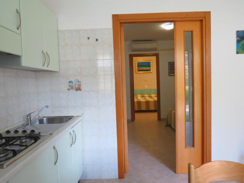 a kitchen with a sink and a door to a hallway at Hotel Residence Villa Ascoli in Vieste
