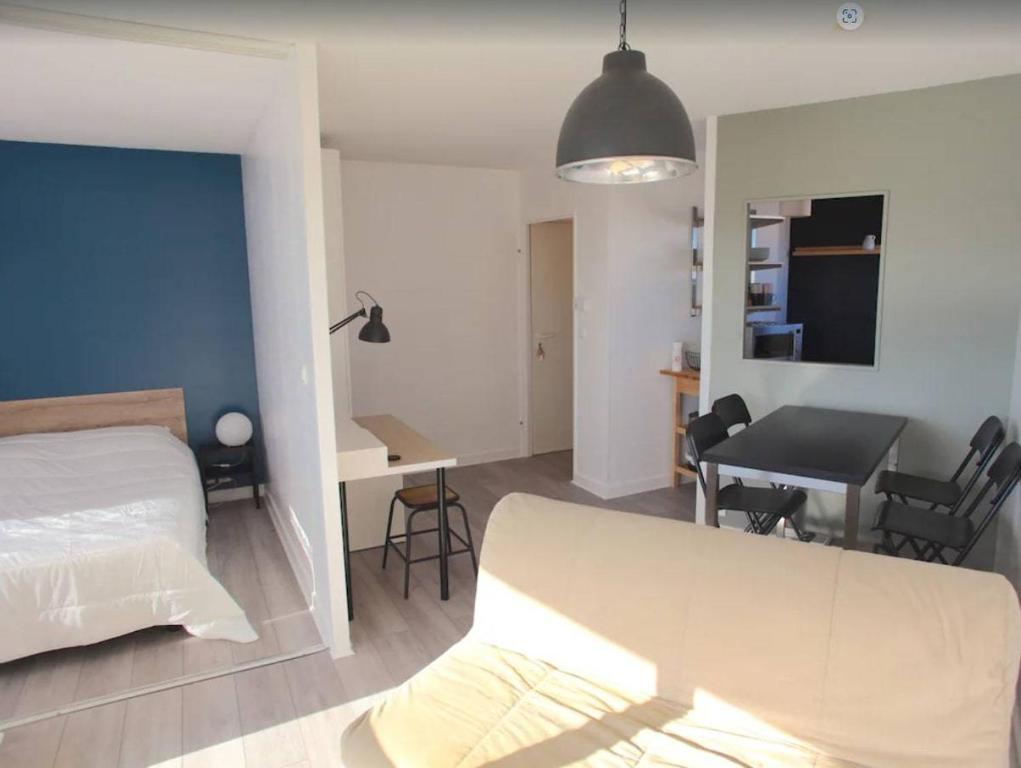 une chambre avec un lit, un bureau et une table dans l'établissement Appartement T1 bis - LA ROCHELLE - LR130-B56, à La Rochelle