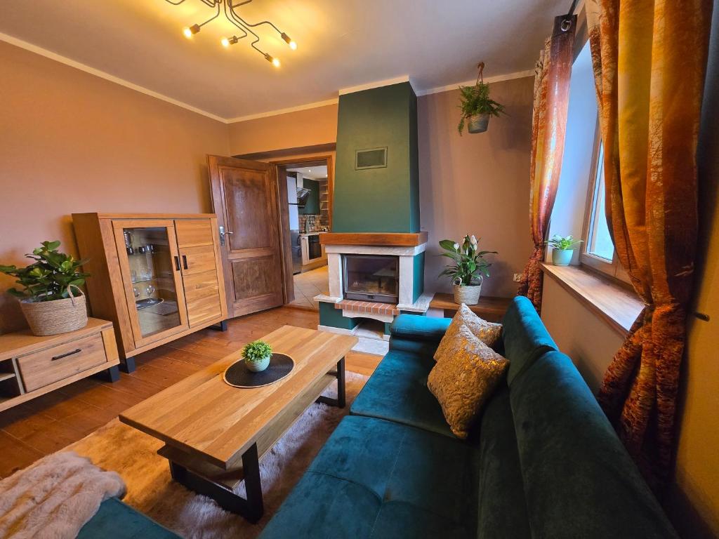 een woonkamer met een blauwe bank en een tafel bij Gniazdko Czarodzieja in Jedlina-Zdrój