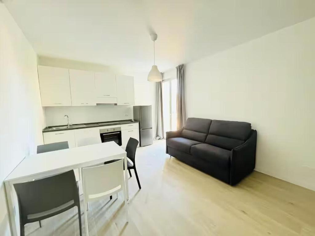 a living room with a black couch and a table at Villa Dune - Centrale - Immobil Relax in Lido di Jesolo