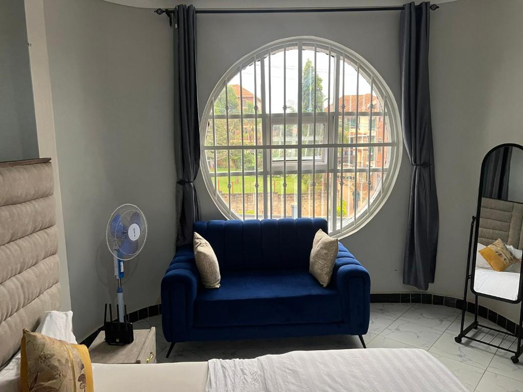 a blue chair in a room with a large window at Studio5 in Munyonyo