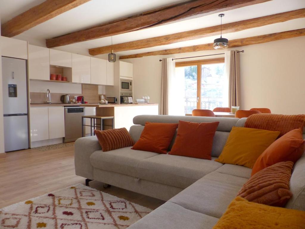 un salon avec un canapé et une cuisine dans l'établissement La grange de Babelli, à Valdeblore