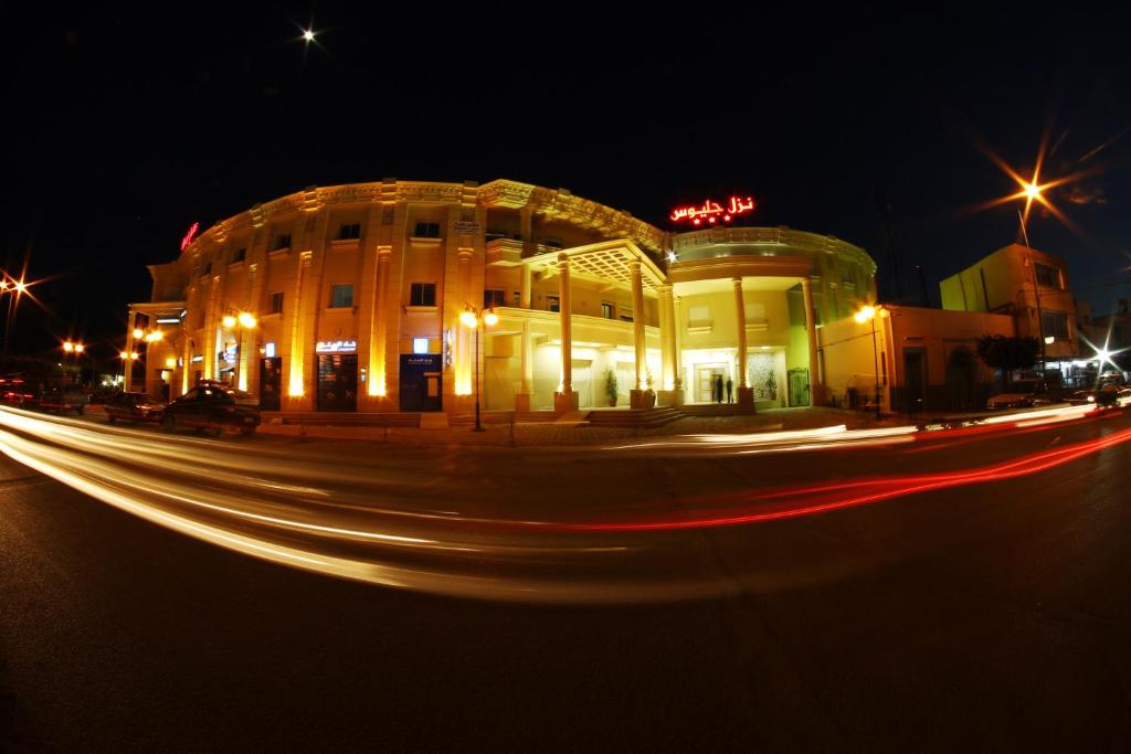 ein Gebäude in der Nacht mit Lichtstreifen vor der Tür in der Unterkunft Hotel Julius in El Jem