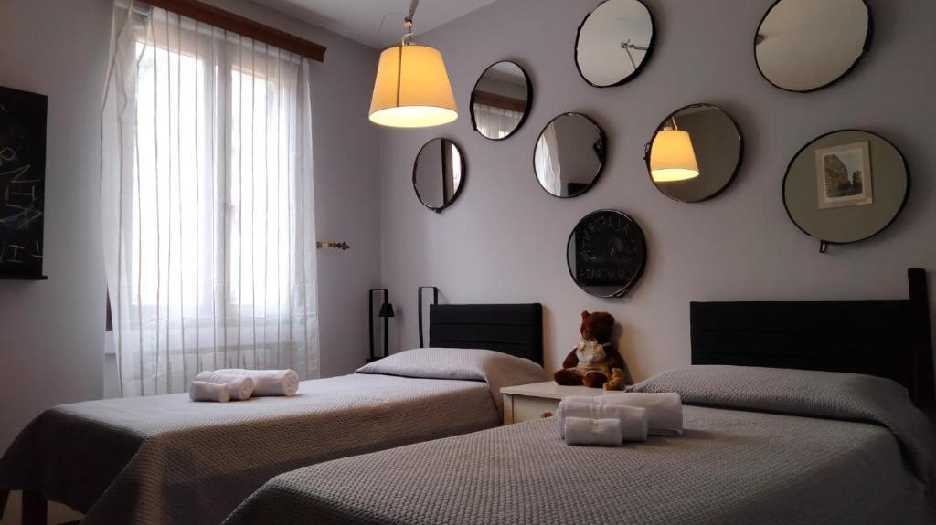 een kamer met drie bedden en spiegels aan de muur bij Vesto VISTA in Marone