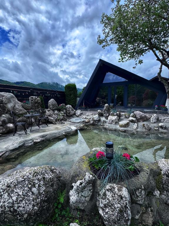 a pool of water with rocks and a bridge at Lago House Bran in Bran