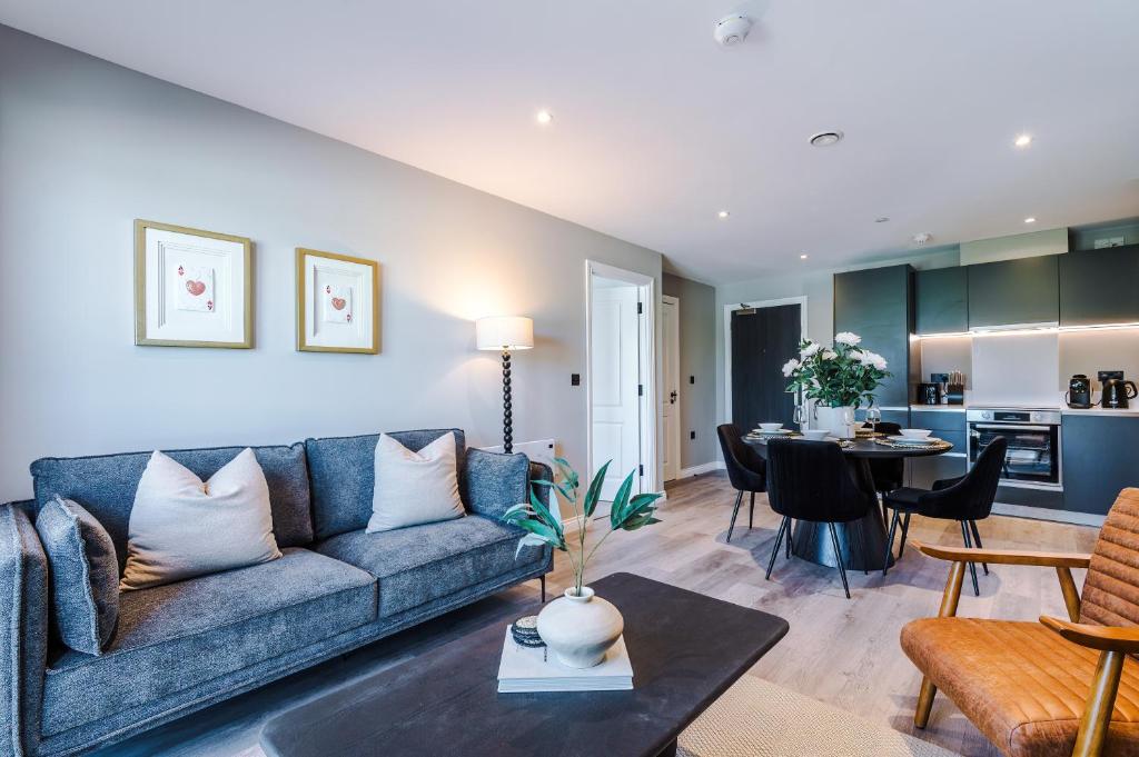 a living room with a blue couch and a table at Leeds City Centre - HIGH SPEC!! Stunning 2 Bedroom Apartment BRAND NEW!! in Beeston Hill