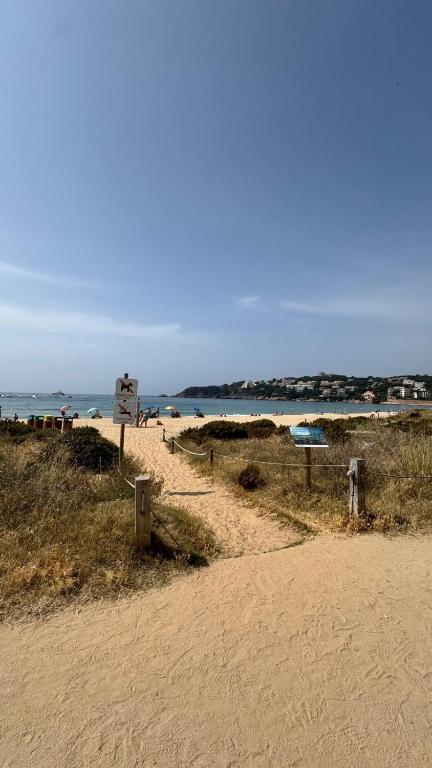 a sandy beach with a path leading to the ocean at S'agaró Mar in Sant Feliu de Guíxols