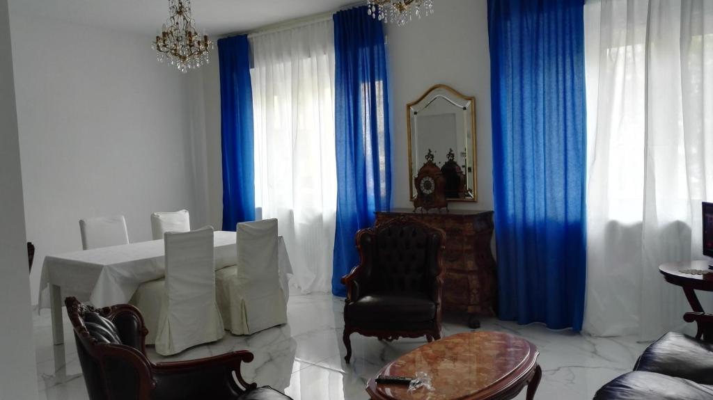 a living room with a table and blue curtains at B&B Casa Nizza in Turin