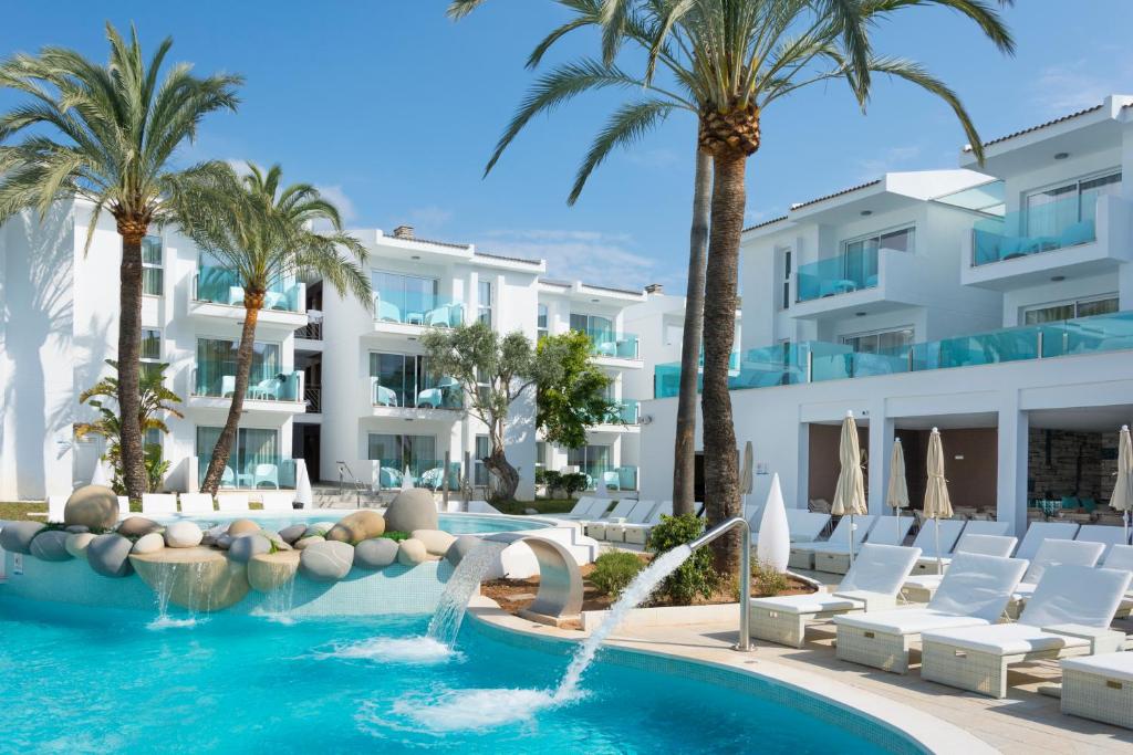 a hotel with a swimming pool and palm trees at MarSenses Puerto Pollensa Hotel & Spa in Port de Pollensa