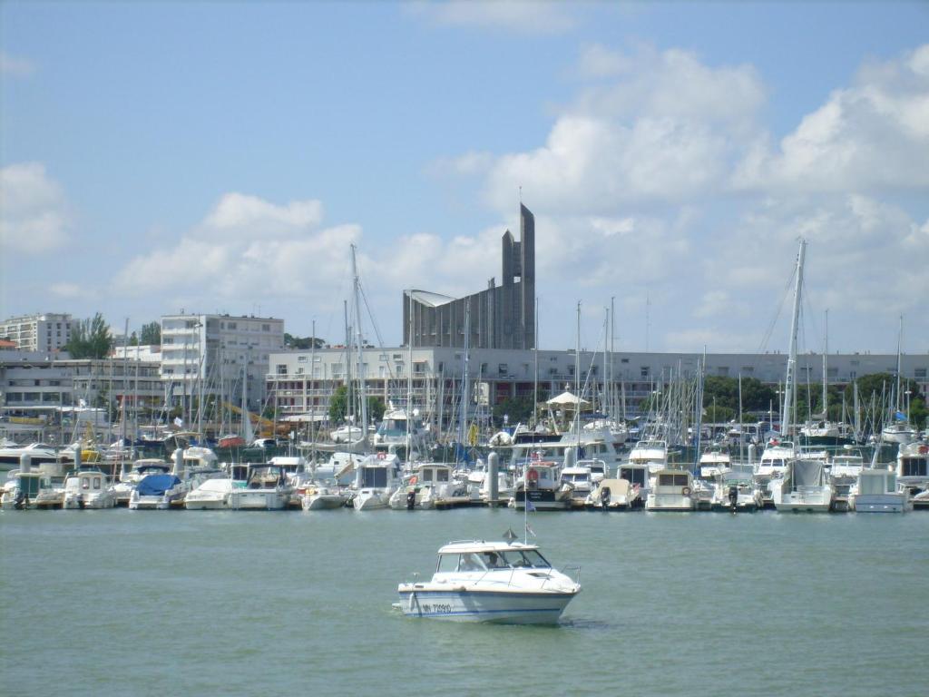 un bateau dans l'eau près d'un port avec des bateaux dans l'établissement Appartement 2 chambres proche de la plage, à Royan