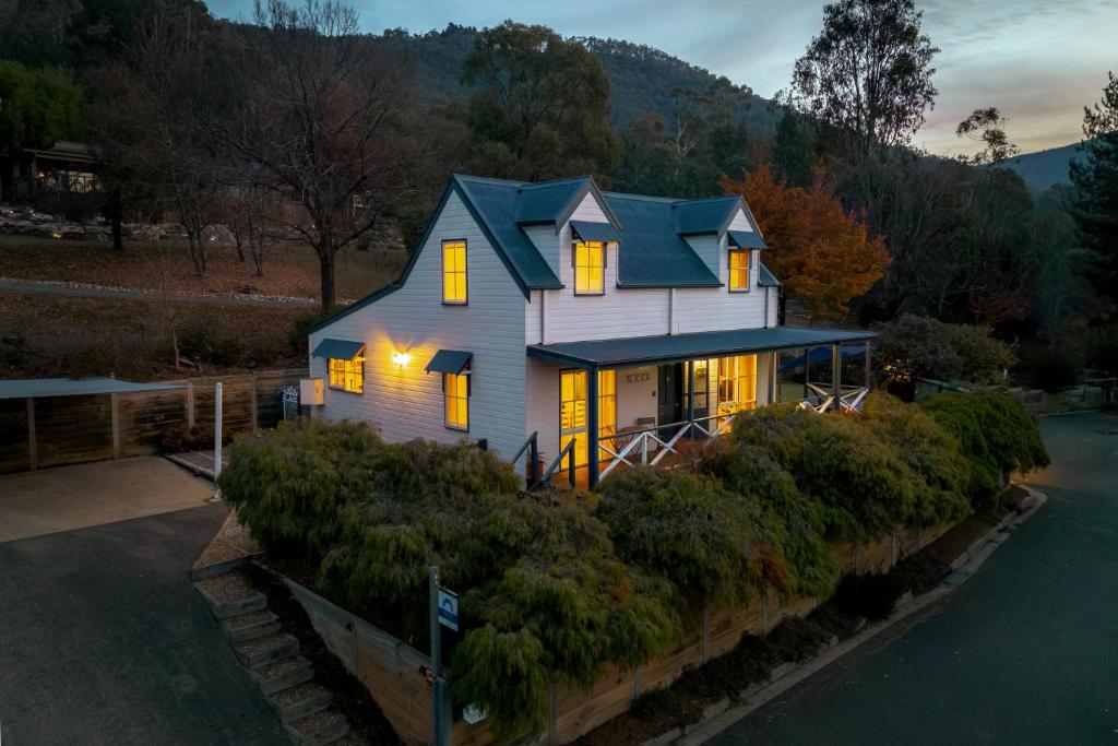 ein Haus auf einem Hügel mit eingeschaltetem Licht in der Unterkunft BlueMill Cottage in Bright