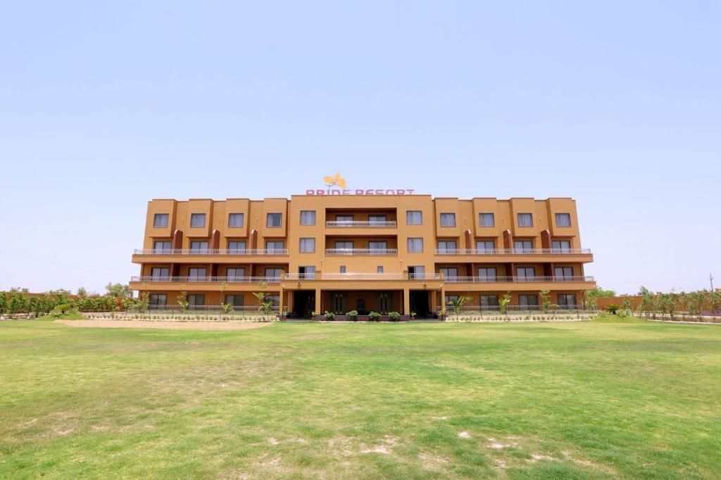a large building with a large field in front of it at Pride Resort Jodhpur in Banār