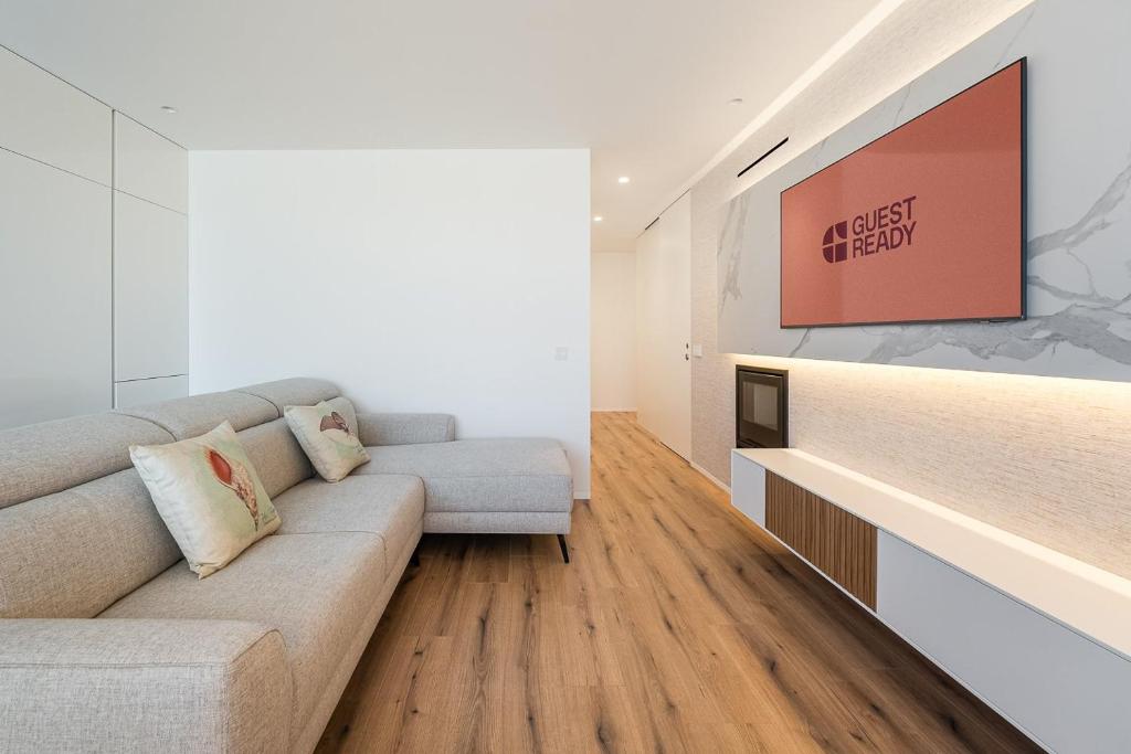 a living room with a couch and a tv at GuestReady - A charming place in a private condo in Apúlia
