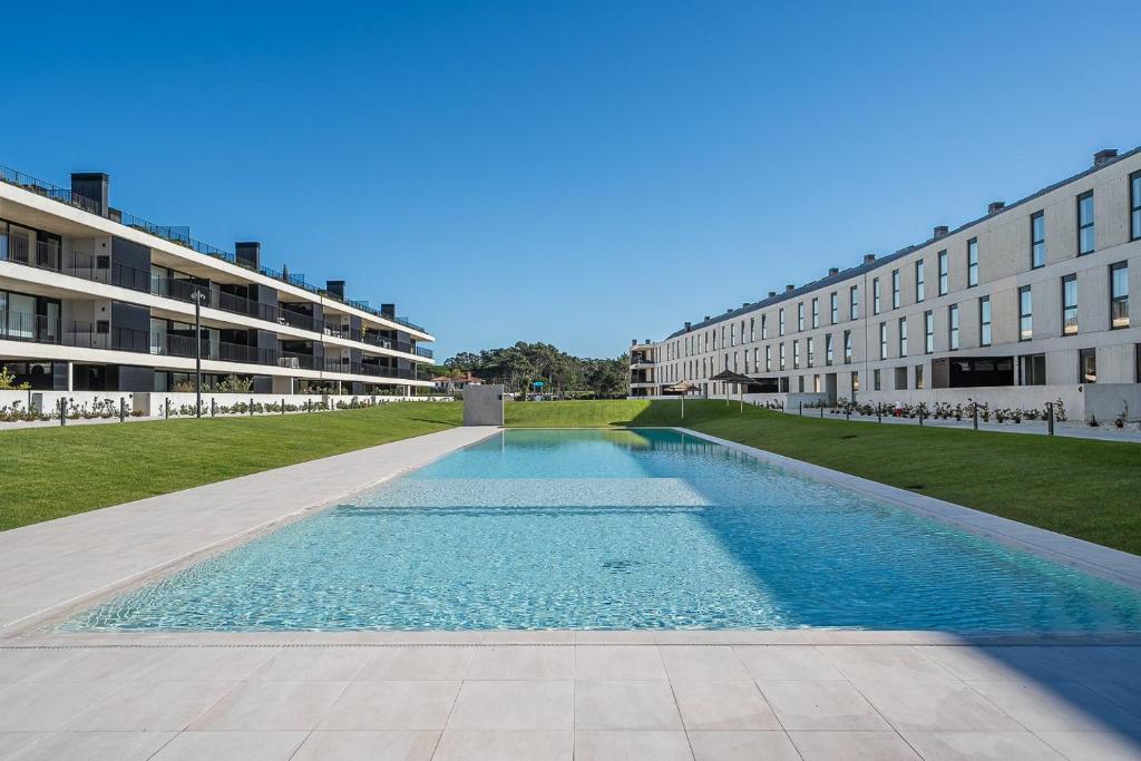 an empty swimming pool in front of a building at GuestReady - A charming place in a private condo in Apúlia