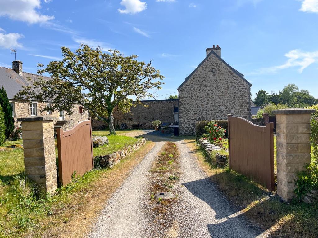 un chemin de terre devant une maison avec une clôture dans l'établissement Authentique Maison au coeur de Rocheville, 