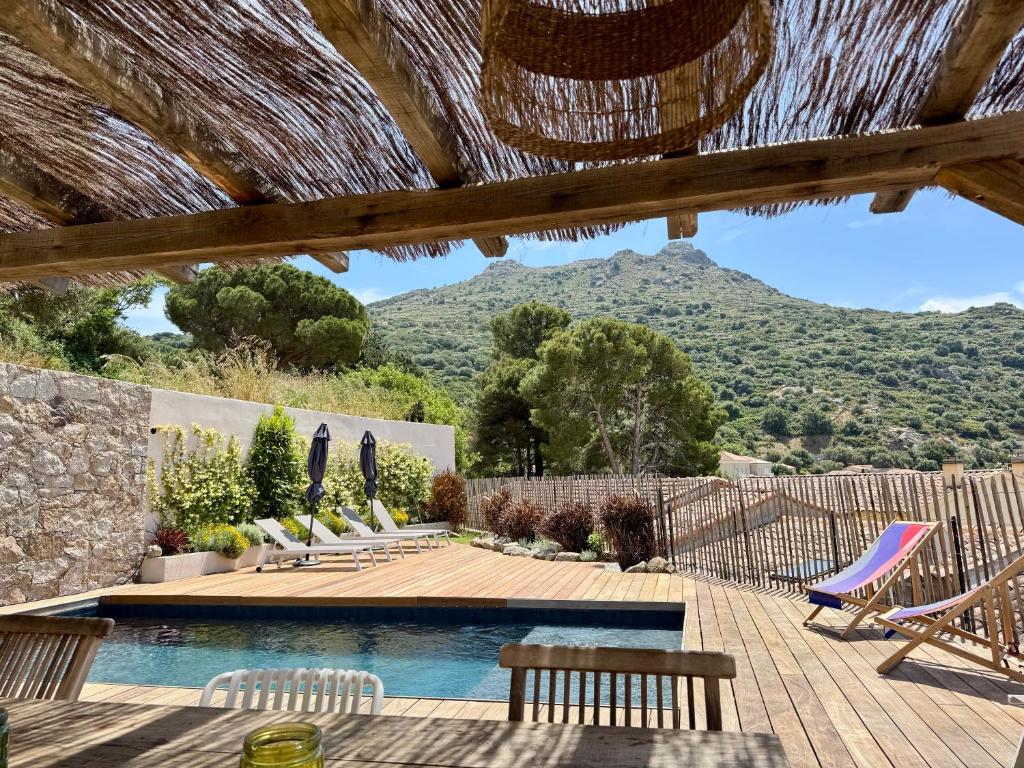 a patio with chairs and a swimming pool with mountains in the background at Villa Casa Savelli in Corbara