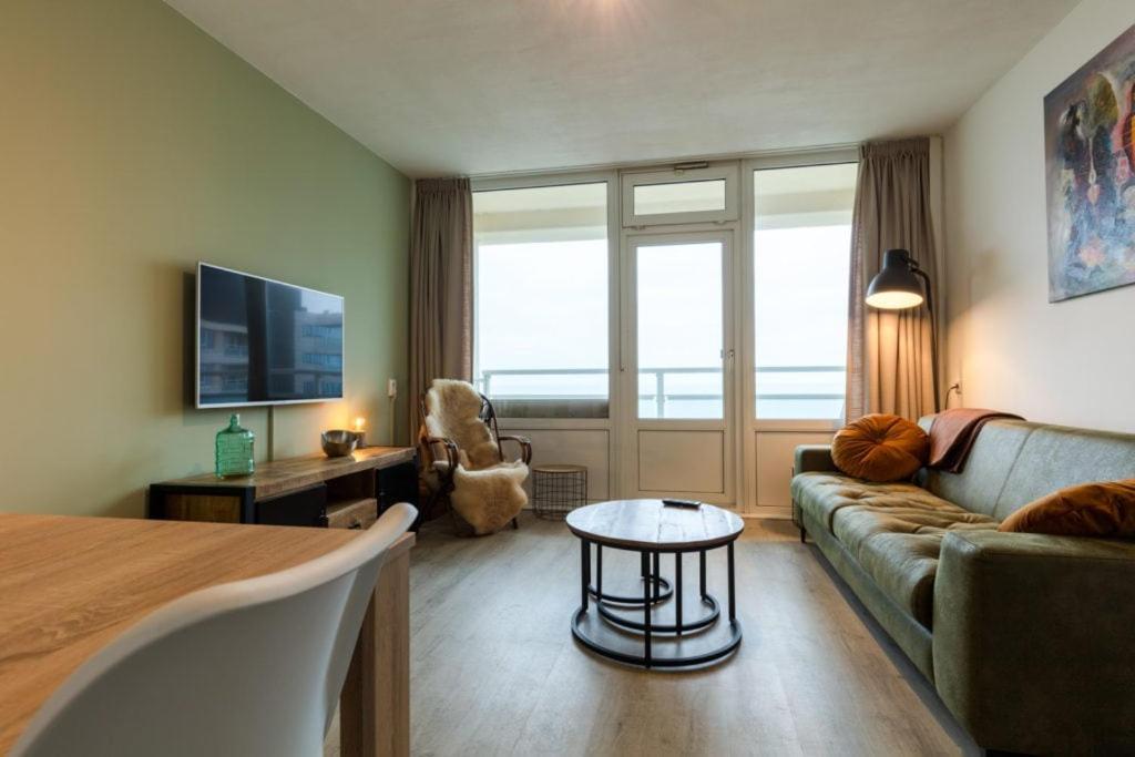 una sala de estar con un sofá y una mesa en Strand166, en Egmond aan Zee