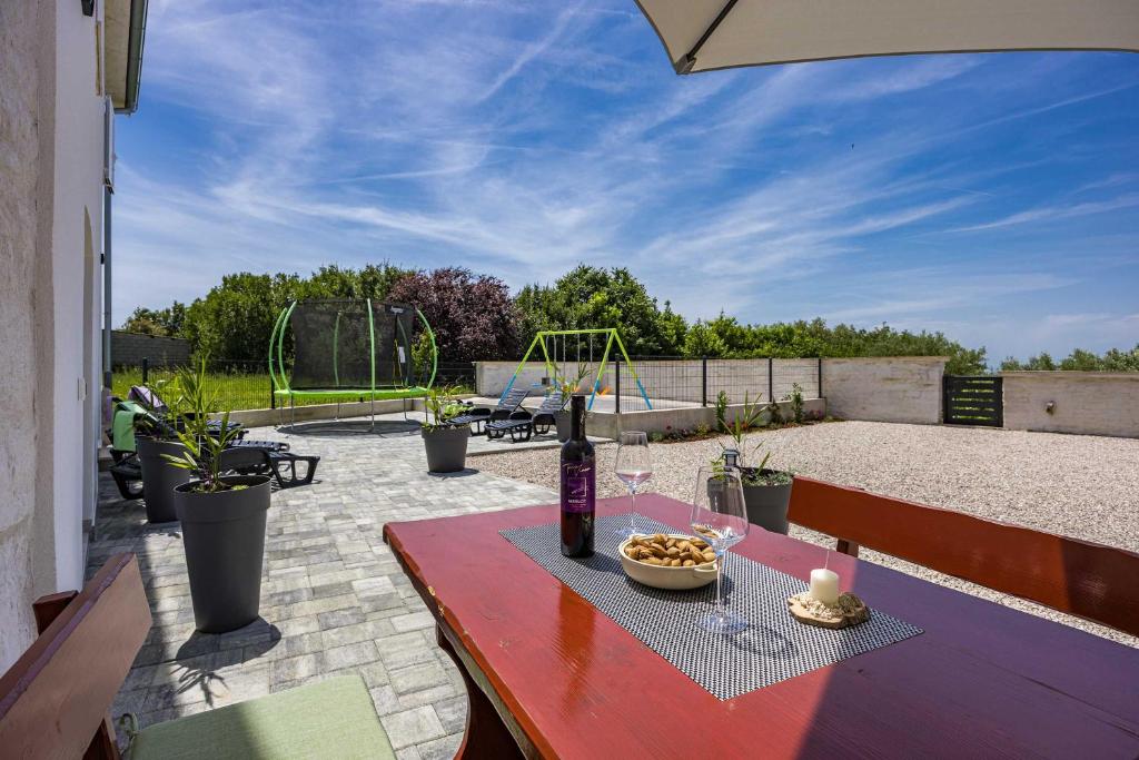 a table with a bottle of wine and a bowl of food at Lara Holiday Home in Kanfanar