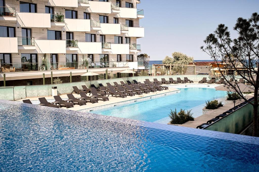 a swimming pool in front of a building at Ricky Apartment in Infinity Spa & Pool in Mamaia Sat/Năvodari