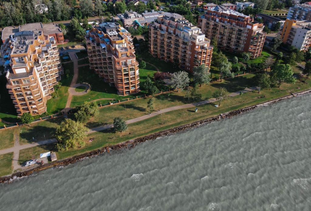 an aerial view of buildings next to a body of water at BALA Resort Apartman in Siófok