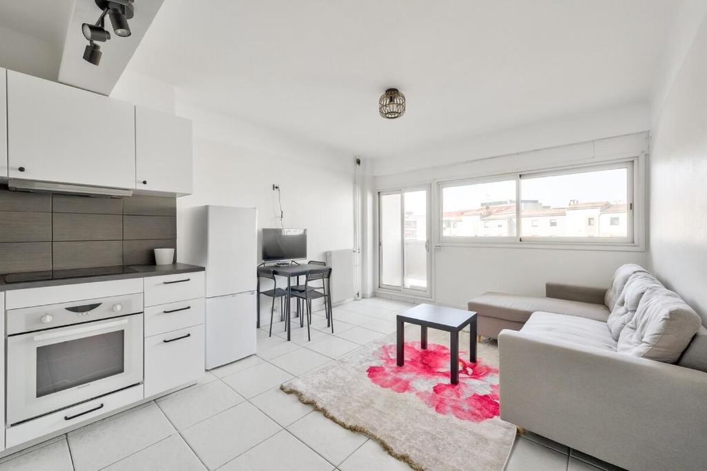 une cuisine et un salon avec un canapé et une table dans l'établissement T3 avec balcon proche de La Place Castellane, à Marseille