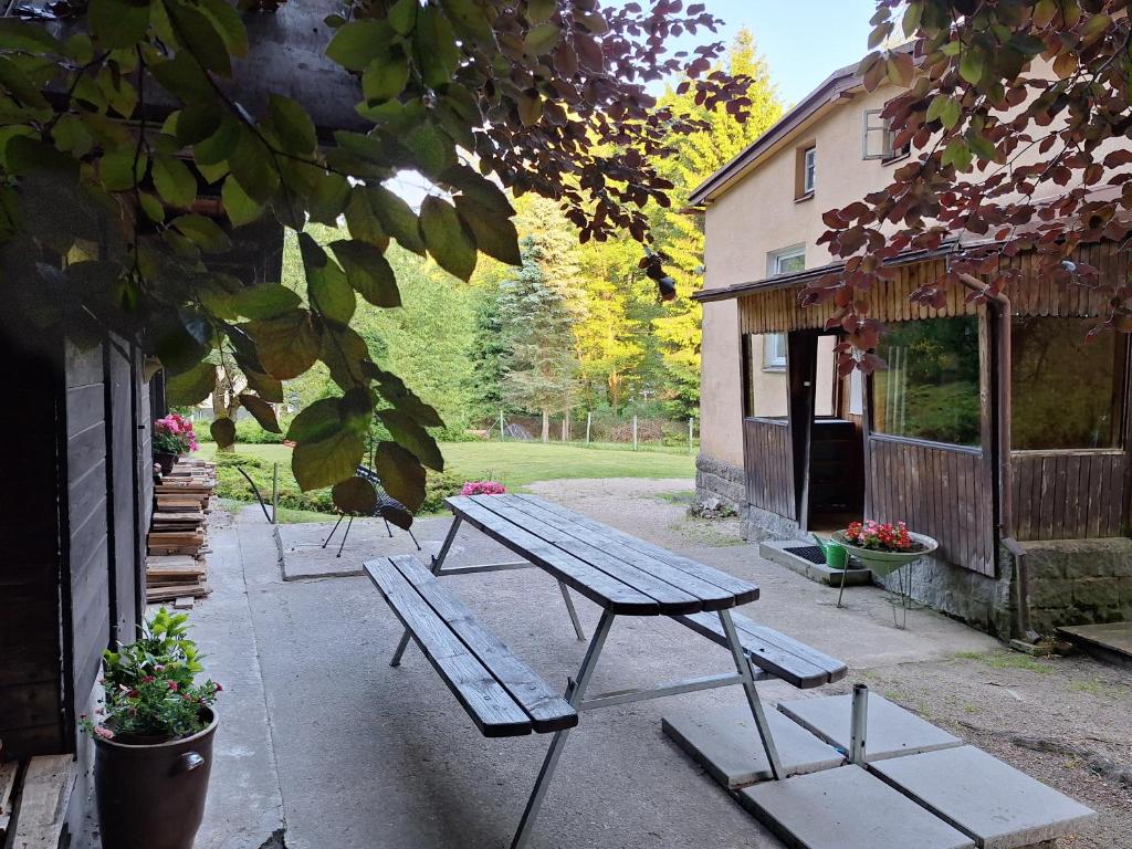 a picnic table and benches outside of a building at Ubytování U Trůdy in Smržovka