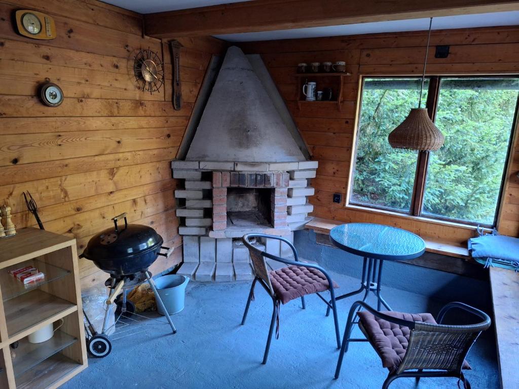 a room with a fireplace and a table and chairs at Ubytování U Trůdy in Smržovka