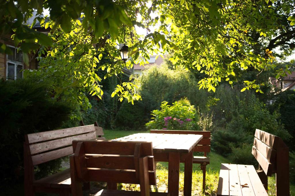 dois bancos de madeira e uma mesa num jardim em Willa "Mazowsze" em Nałęczów