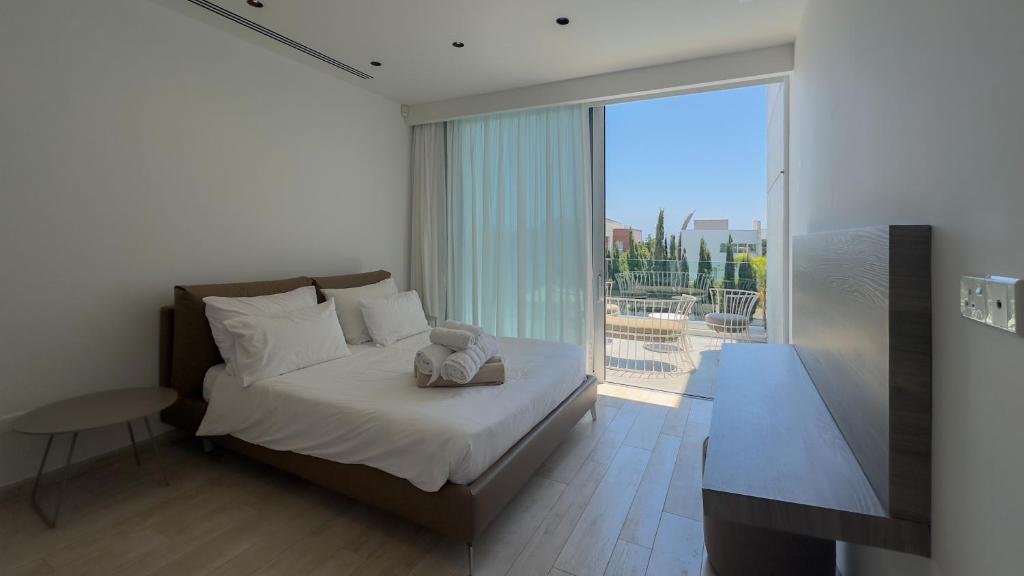 a bedroom with a bed and a large window at Vivo Mare 3 Bedroom Villas in Ayia Napa