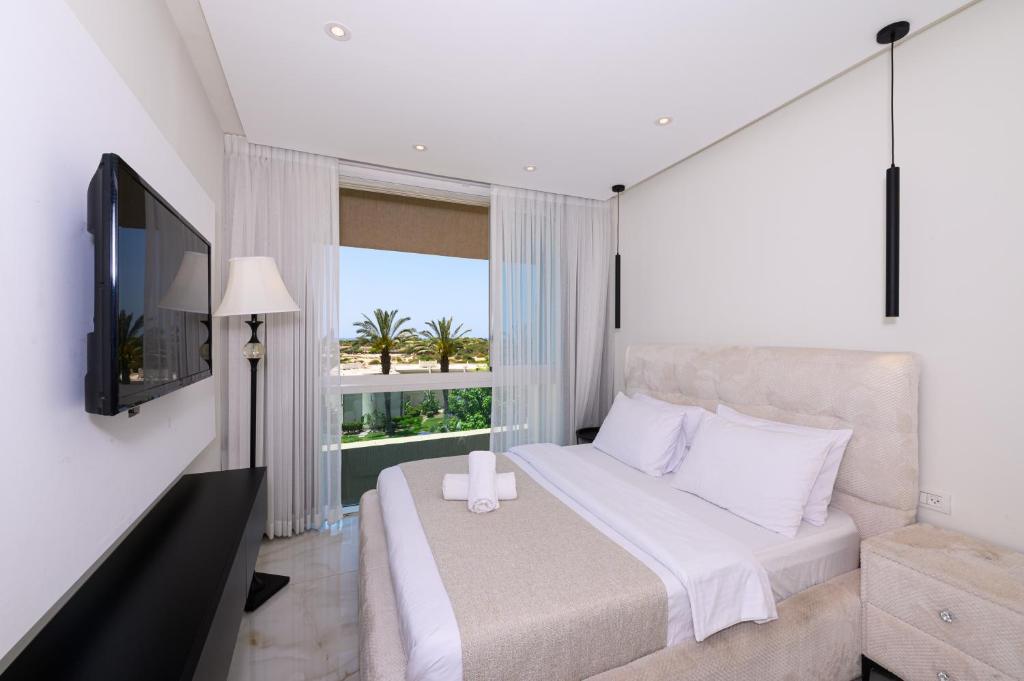 a bedroom with a bed and a large window at Royal Suite Caesarea in Caesarea