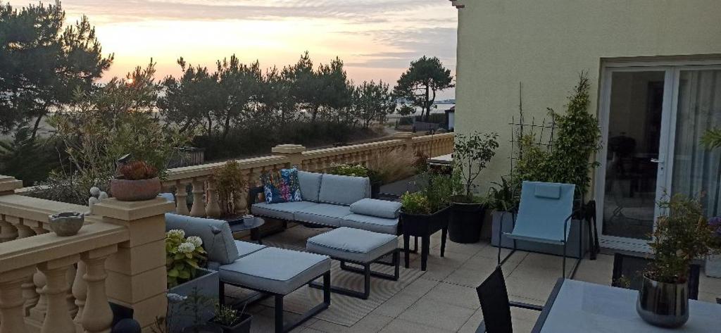 d'une terrasse avec des chaises et un canapé sur un balcon. dans l'établissement 125M2 FACE MER ST BRéVIN, à Saint-Brévin-les-Pins
