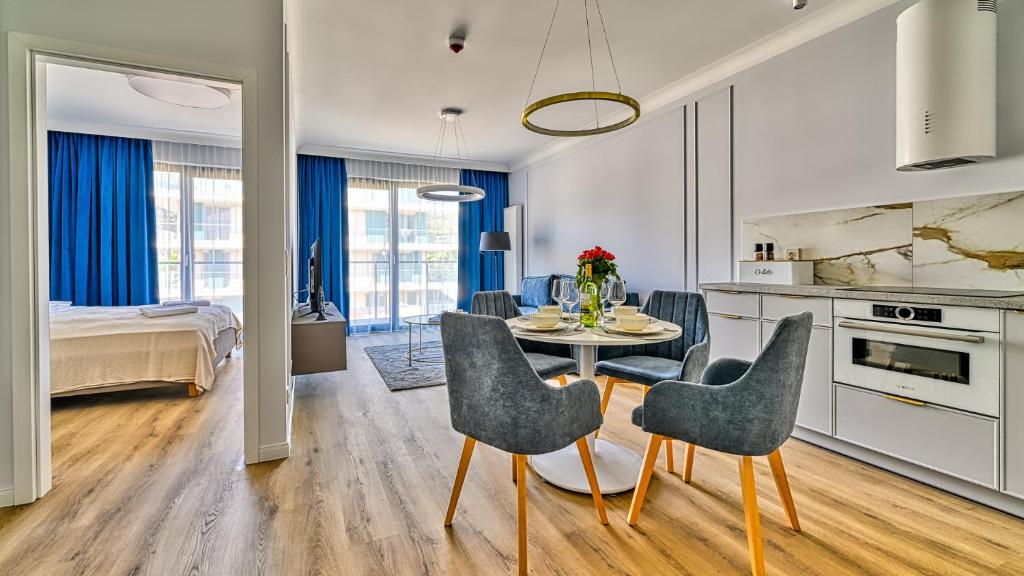 eine Küche und ein Esszimmer mit Tisch und Stühlen in der Unterkunft Rezydencja Niechorze D203 Classik z 2 sypialniami - 5D Apartments in Niechorze