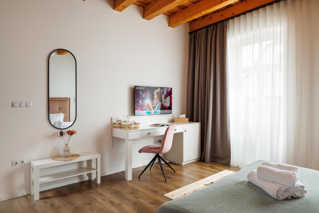 a bedroom with a desk and a bed and a mirror at Richter Residence in Braşov