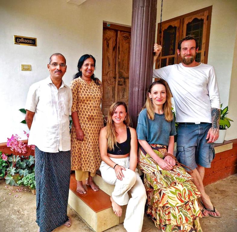 Un gruppo di persone che posano per una foto davanti a una casa di Centre Home Homestay Wayanad a Kalpetta