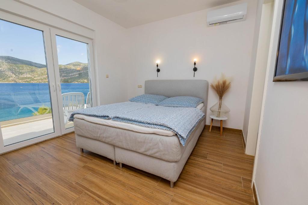 a bedroom with a bed and a large window at Apartmani Katarina in Pupnat