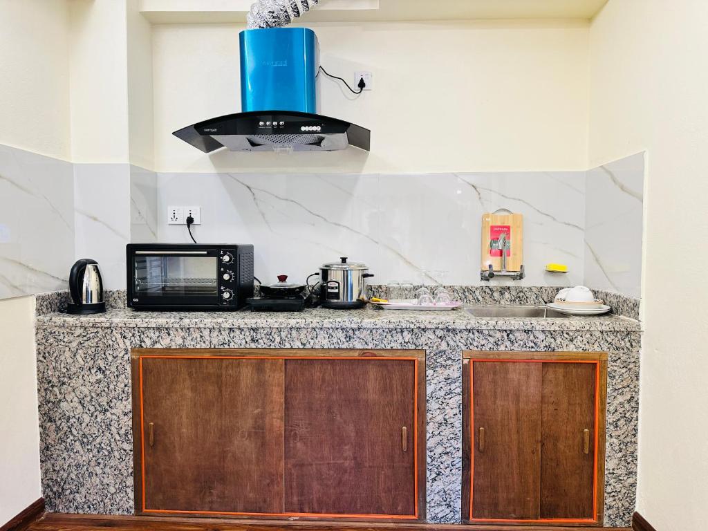 a kitchen with a counter top with a microwave at Yogi's Heritage in Patan - Heritage Family Studio in Pātan