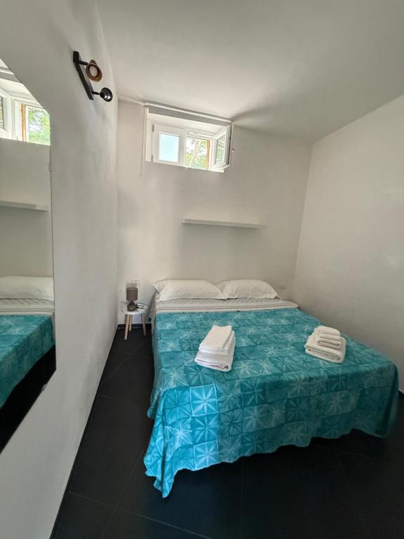 a small bedroom with a bed and a window at Tosk House in Peschici