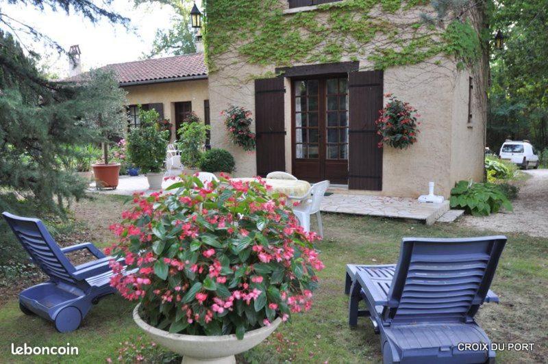 deux chaises bleues et un pot de fleurs devant une maison dans l'établissement le pigeonnier, à La Celle-sous-Gouzon