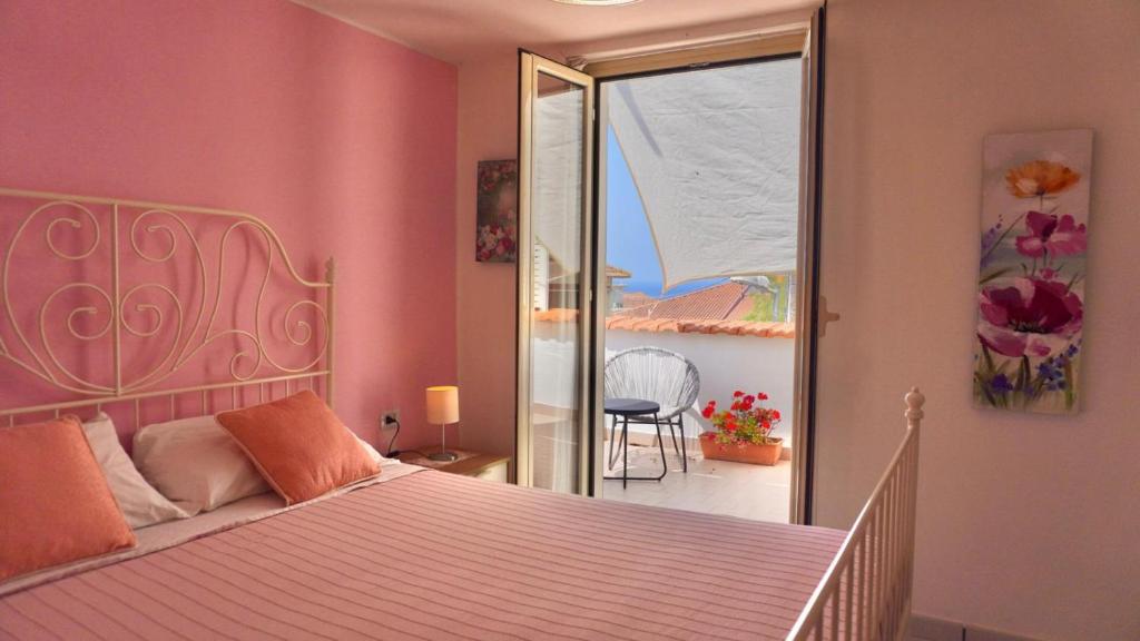 a bedroom with a bed and a view of a balcony at Caramico Room in Castellabate