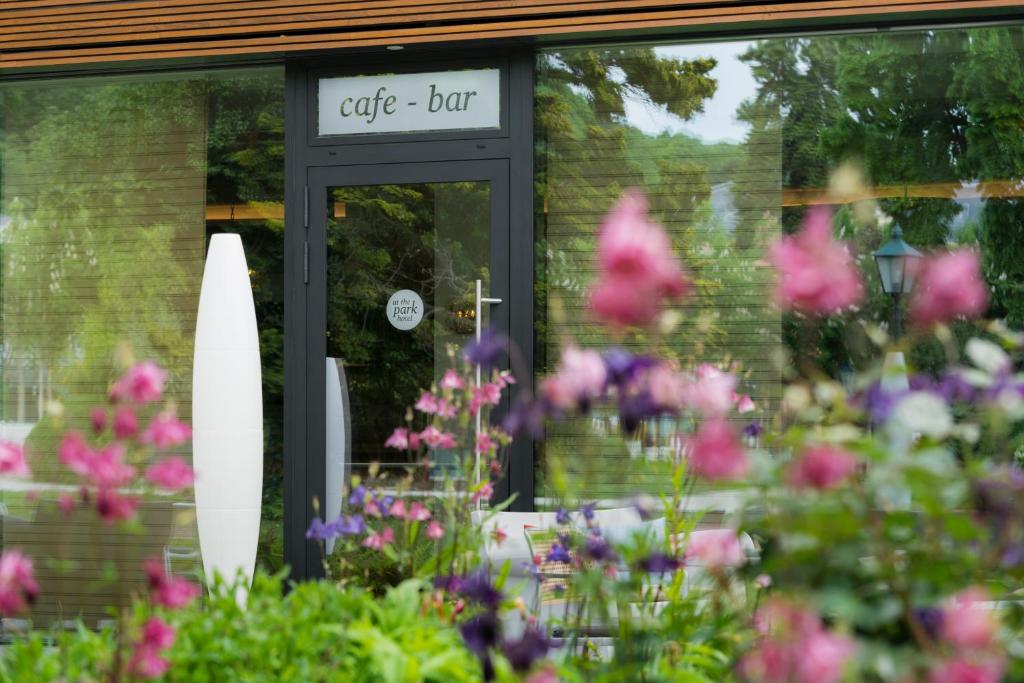 a cafe but sign in front of a door with flowers at At the Park Hotel in Baden